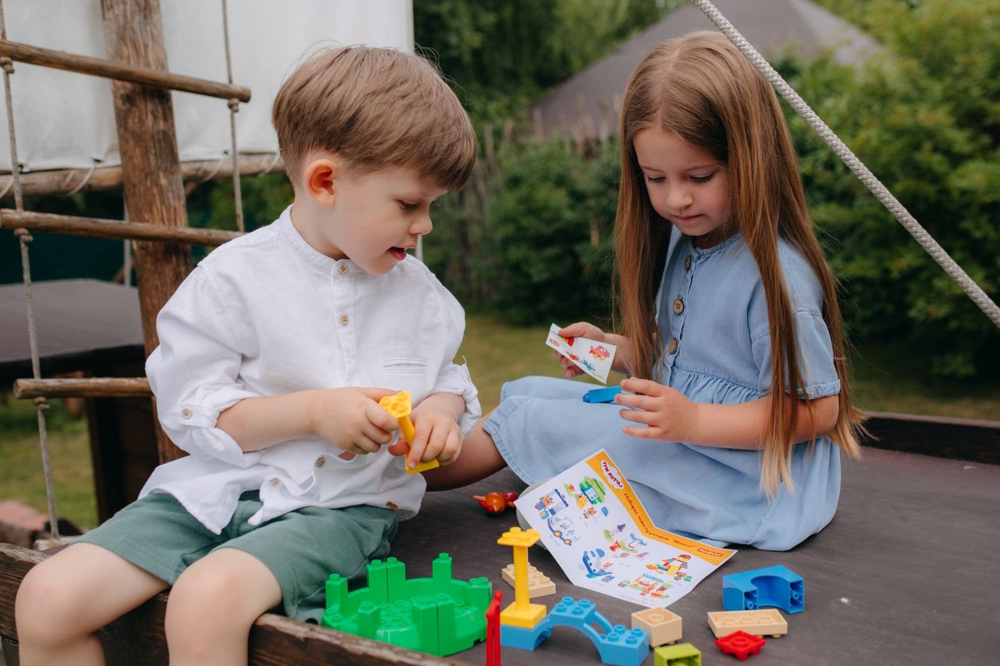 Two young children exploring building blocks together at a low classroom table
